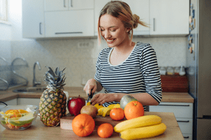 žena v kuchyni krájajúca ovocie - ovocná diéta
